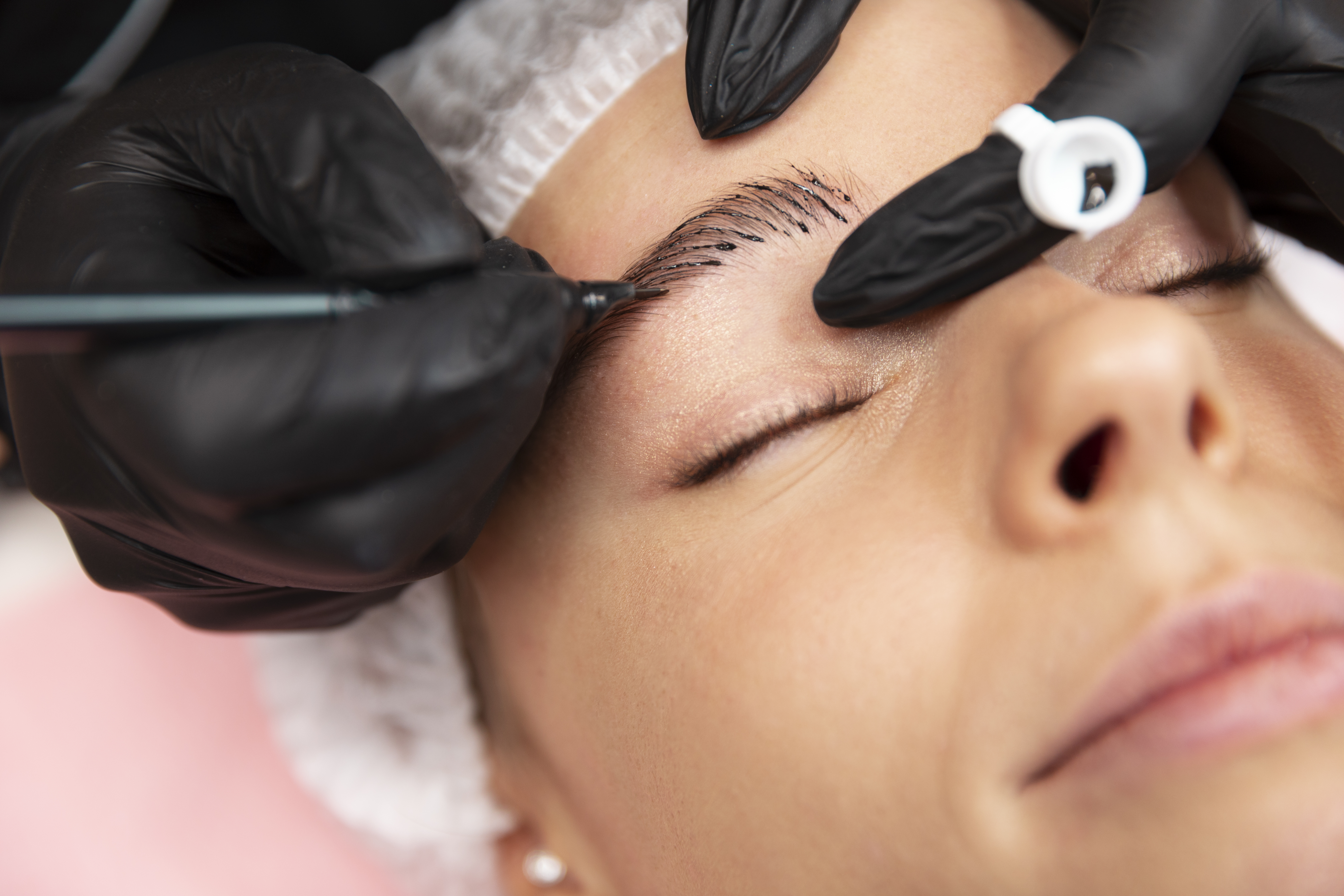 Especialista en cejas en Bogotá trabajando el diseño de una clienta